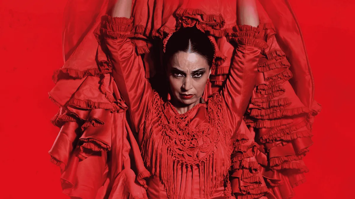 Flamenco dancer in a red dress on the small stage of Teatro Flamenco Barcelona during a flamenco show in Barcelona, Spain